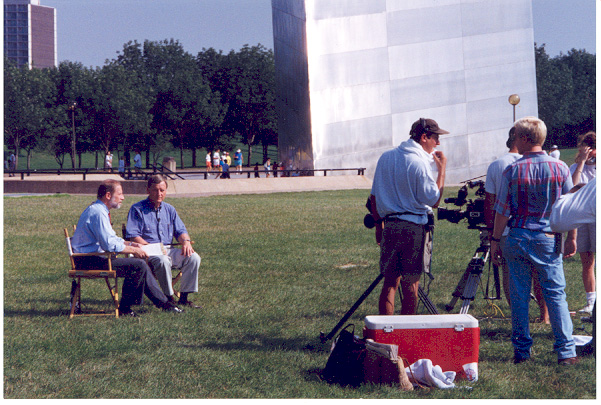 Governor Mel Carnahan, seated on the right, gives an interview to the news media during the 1993 flood at the Jefferson National Expansion Memorial (Arch).